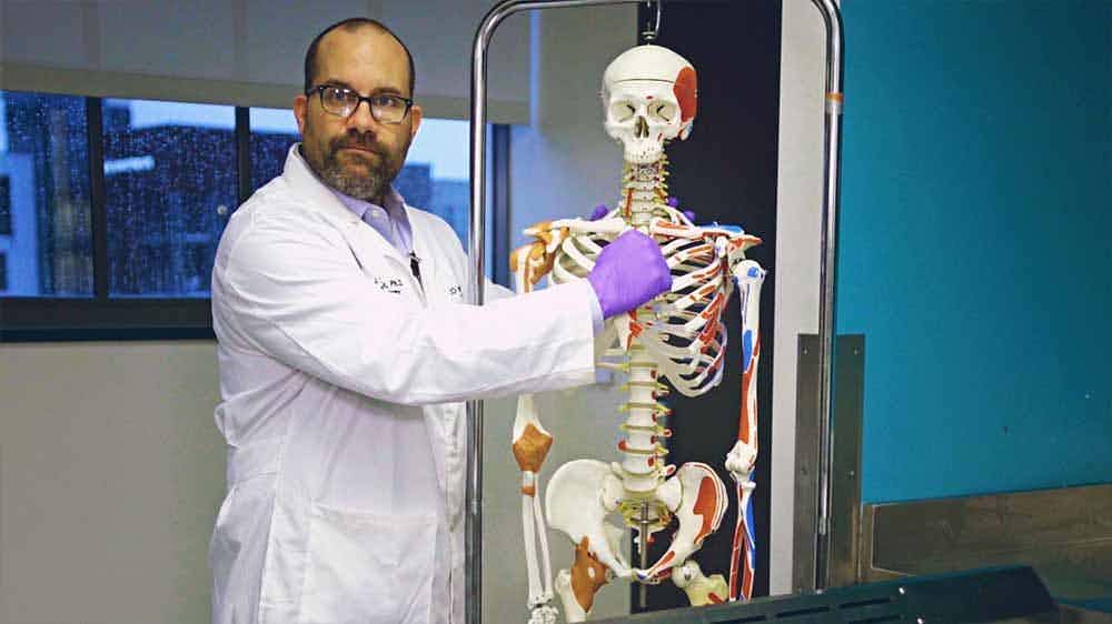 Wake Forest Medicine Course professor alongside a skeleton 