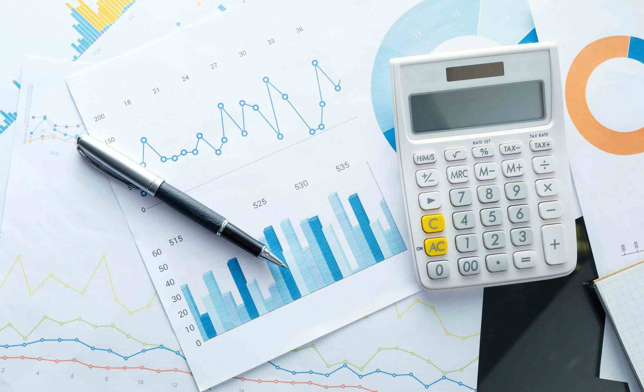 Calculator and graphs with a pen on a table