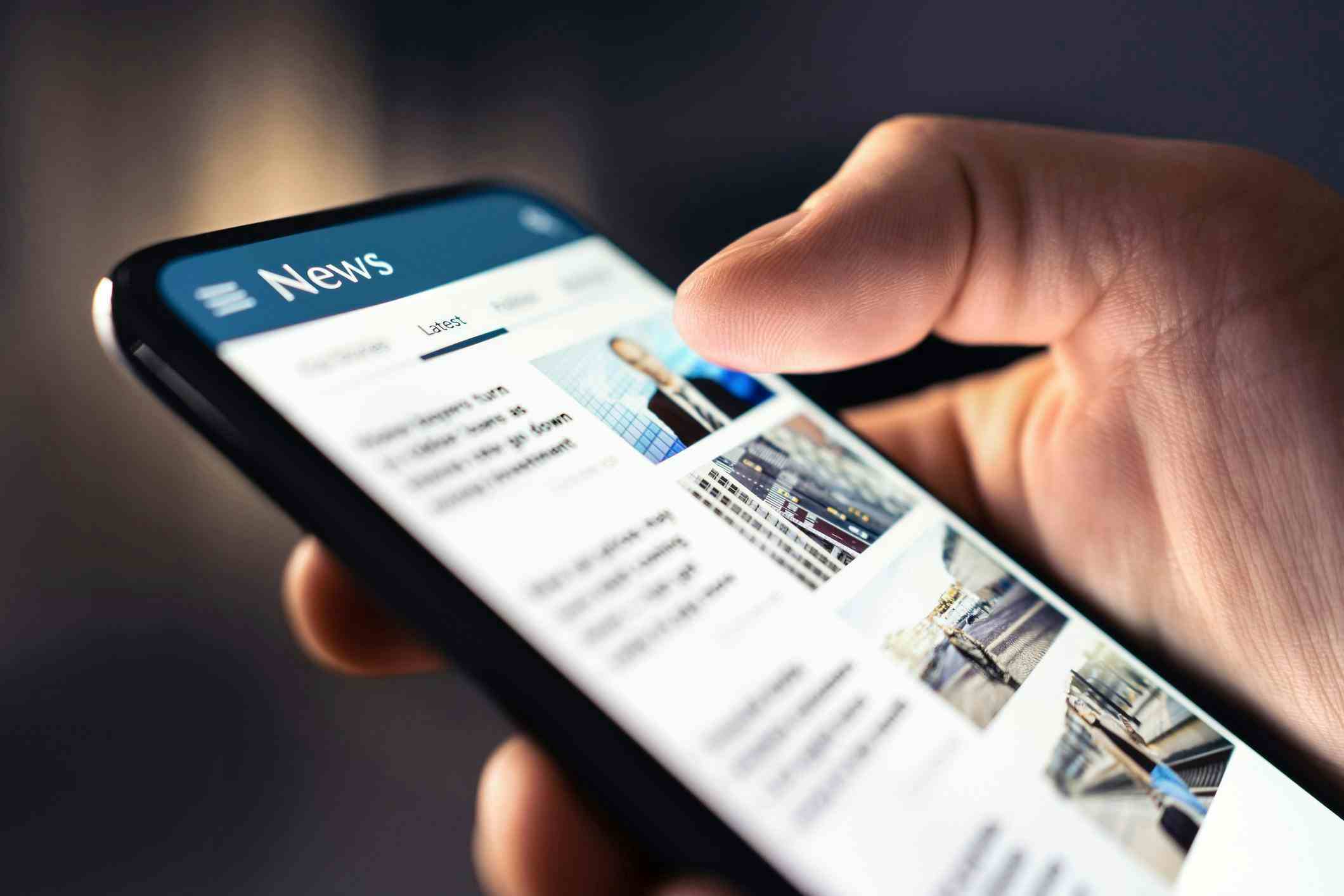 Up close of person holding a smartphone looking at news stories