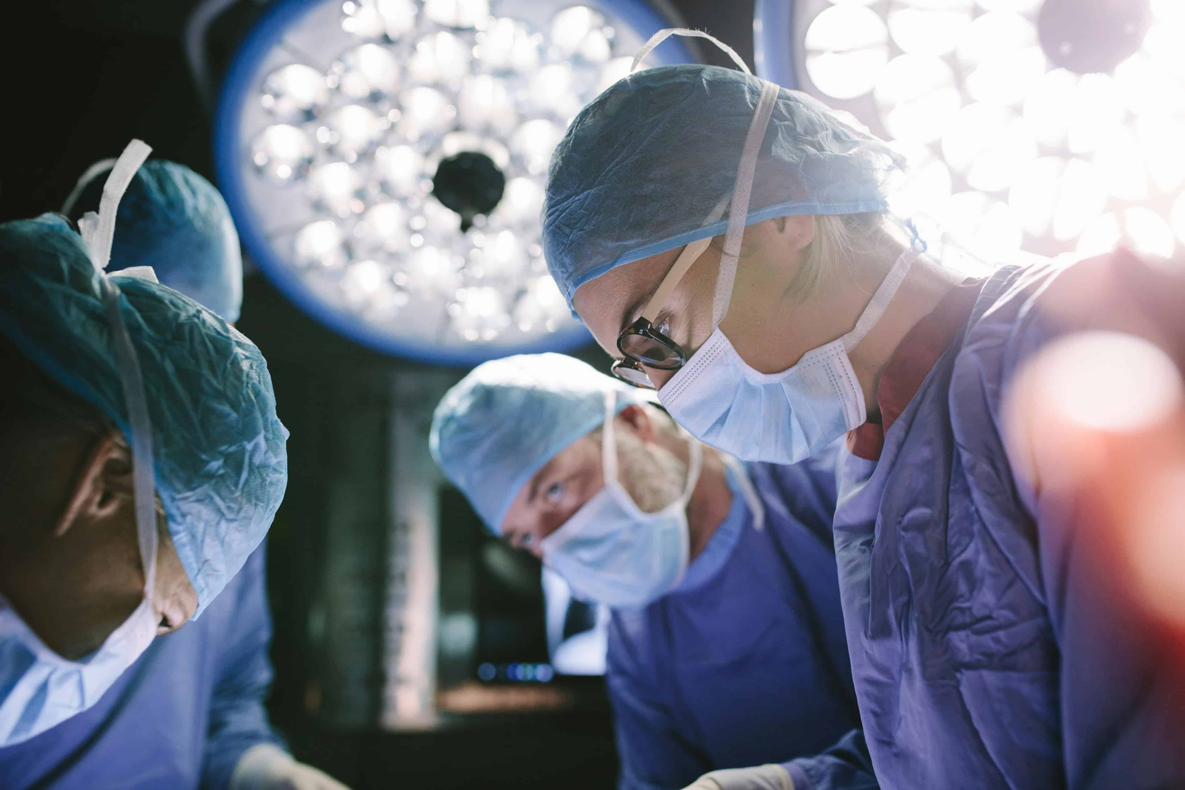 Masked up doctors performing procedure