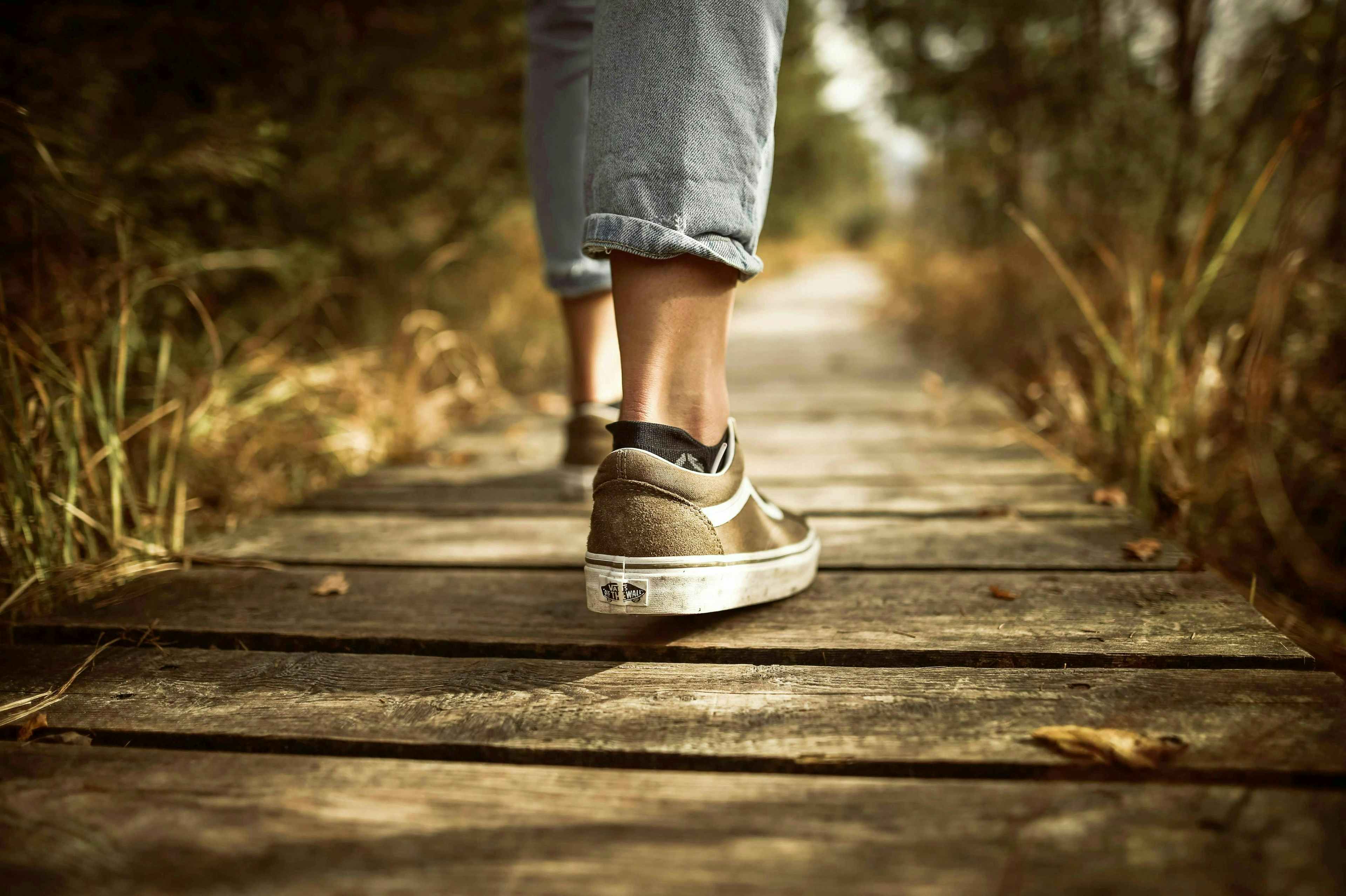 Teen wearing sneakers walking on path