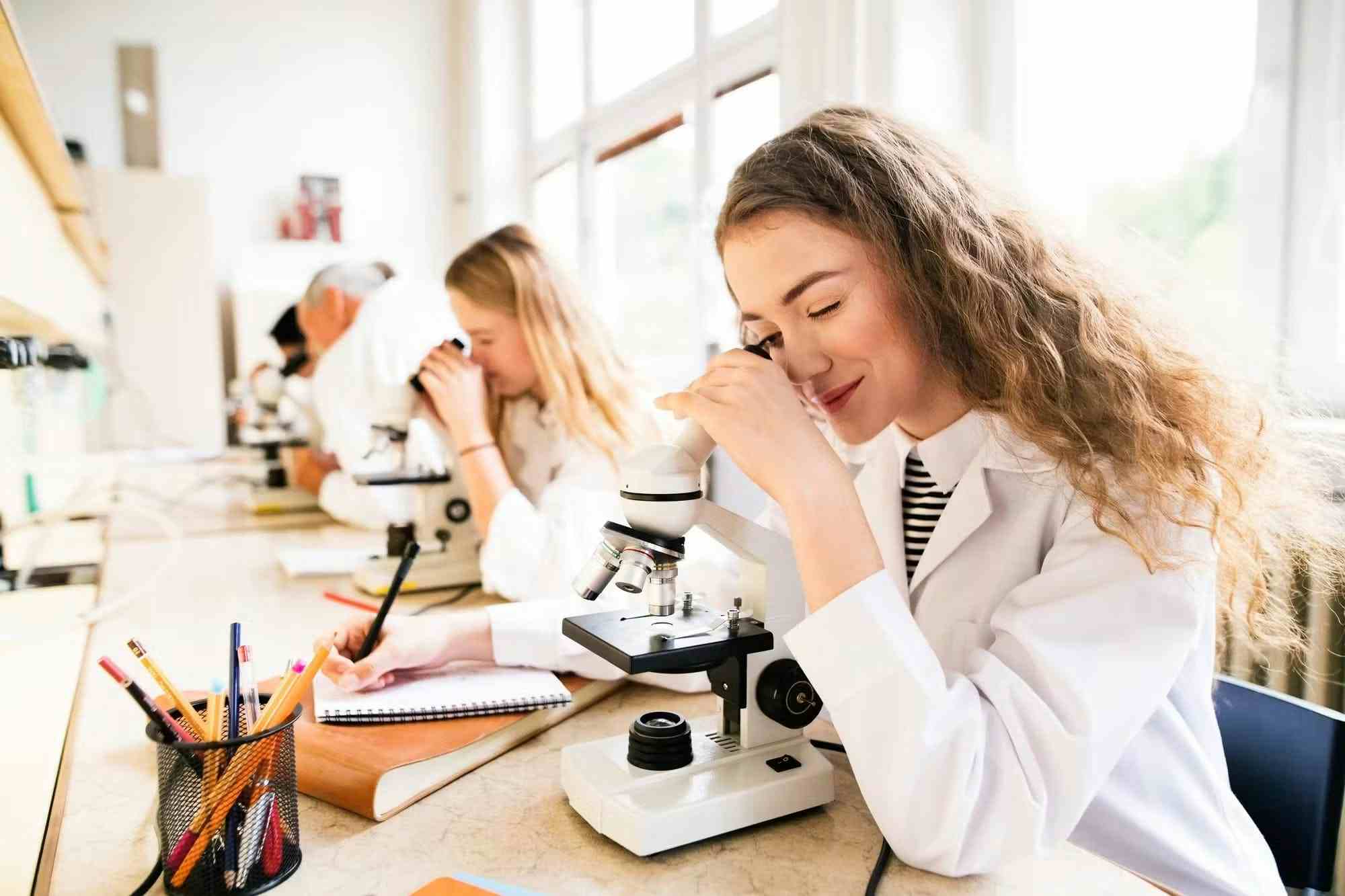 High School student learning about medicine with microscope 